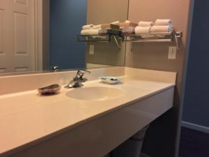 a bathroom counter with a sink and a mirror at The Oceanfront Inn in Shelter Cove