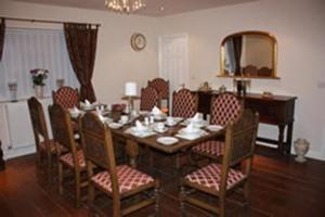 a dining room with a table with chairs and a mirror at The Anvil Lodge in Shifnal