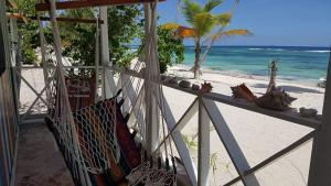 a porch with a hammock on the beach at Casa Rural El Paraíso de Saona in Mano Juan