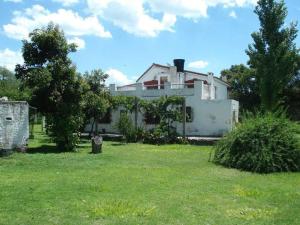 una casa blanca con un patio con césped verde en Doña Haydee en 