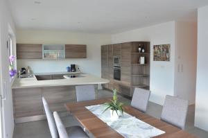 uma cozinha e sala de jantar com uma mesa de madeira e cadeiras em Family Apartment Julia em Termeno