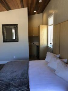 een slaapkamer met een wit bed en een spiegel aan de muur bij Stone Canyon Inn in Tropic