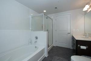 a bathroom with a tub and a toilet and a sink at Pentagon City Luxury Apartment in Arlington