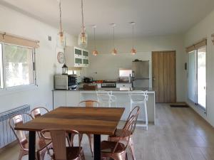 a kitchen with a wooden table and chairs at la casa de los pájaros in San Pedro