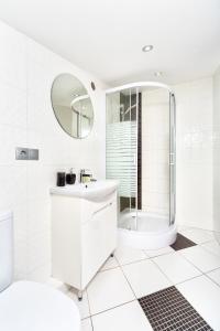 a white bathroom with a shower and a sink at Langery Residence Central Apartments in Odesa +74 photos