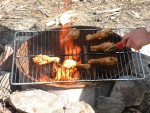 a person is cooking food on a grill at Johannisholm Adventure in Johannisholm