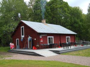 a red barn with a picnic table in front of it at Johannisholm Adventure in Johannisholm