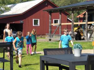 a group of children walking in front of a red barn at Johannisholm Adventure in Johannisholm
