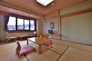 a living room with a table and chairs and a window at Hosonokan in Hakuba