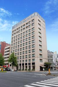 a large white building on a city street at Hotel Keihan Tokyo Yotsuya in Tokyo