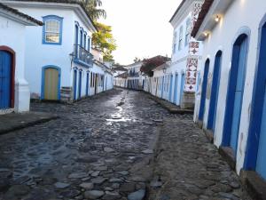 un callejón en una ciudad con edificios azules y blancos en Casa para temporada, en Paraty