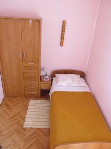 ドゥブロヴニクにあるシニスタイ ルームズの小さなベッドルーム(ベッド1台、キャビネット付)