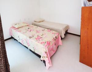a bedroom with two beds with pink sheets at Casa Marilù in Morro de São Paulo