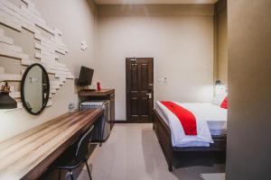 a hotel room with a bed and a mirror at RedDoorz Plus near Mall Slipi Jaya in Jakarta