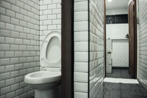 La salle de bains est pourvue de toilettes blanches et d'une fenêtre. dans l'établissement Signature coffee & bed, à Chiang Mai 23 autres photos