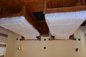 two white beds in a room with wooden ceilings at Selam Guest House in Lalibela