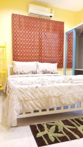 a bedroom with a large bed with a red wall at Aquaman @chalong pier in Chalong