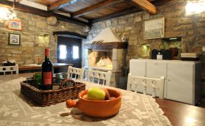 a kitchen with a table with a bowl of fruit and a fireplace at Holiday Homes Poli Svetega Antona in Gračišće