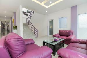 a living room with purple couches and a glass table at RedDoorz Plus near Stasiun Bekasi in Bekasi