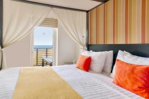 a bedroom with a large bed and a large window at Jetwing Sea in Negombo