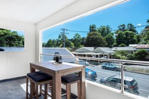 a wooden table on a balcony with a view of a street at Olinda Two Bedroom Apartment - B2 in Olinda