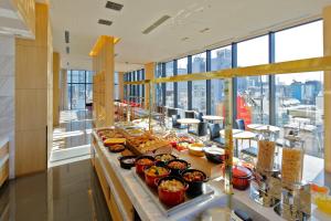 a buffet line with food on it in a building at Candeo Hotels Tokyo Shimbashi in Tokyo