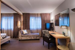 um quarto de hotel com uma secretária e uma cadeira em Museum Apartment Hotel, Independent Collection by EVT em Wellington