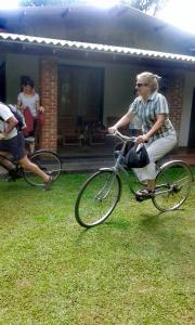 a man riding a bike in the grass at Green Cottage in Anuradhapura
