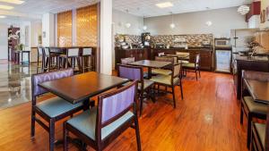 a restaurant with tables and chairs and a kitchen at Best Western Plus O'hare International South Hotel in Franklin Park