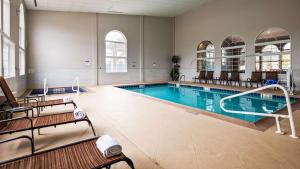 a large pool with chairs and a swimming pool at Best Western Cooperstown in Cooperstown