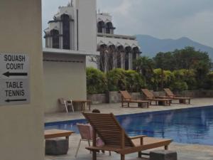 a group of chairs sitting next to a swimming pool at K. Riverfront apartment in Ipoh