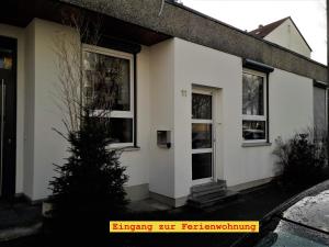 a white house with two windows and a tree at Doppel-Appartement Salzbrunner Str. 11, Langwasser Mitte in Nuremberg