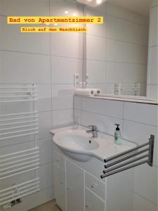 a white bathroom with a sink and a mirror at Doppel-Appartement Salzbrunner Str. 11, Langwasser Mitte in Nürnberg