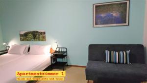 a bedroom with a bed and a couch and a chair at Doppel-Appartement Salzbrunner Str. 11, Langwasser Mitte in Nuremberg