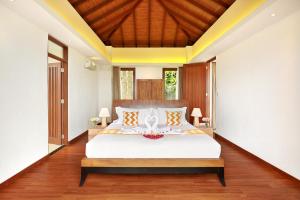 a bedroom with a white bed with a wooden ceiling at Ocean View Villa Hotman Paris VII in Jimbaran +20 photos