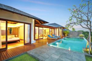 a villa with a swimming pool and a bedroom at Ocean View Villa Hotman Paris VII in Jimbaran