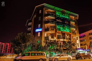 two cars parked in front of a building with green lights at Anik Apart Hotel in Alanya