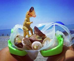 a person holding a plastic toy of a toy dog on a beach at Anik Apart Hotel in Alanya