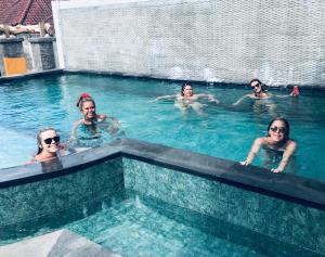a group of people swimming in a swimming pool at D'Yuki Huts Lembongan in Nusa Lembongan