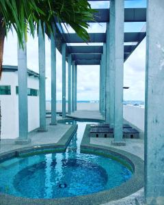 a pool in the middle of a building with columns at JB-Singapore Paragon Suites Homestay in Johor Bahru
