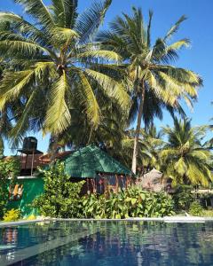 un complexe avec des palmiers et une piscine dans l'établissement Bella Nilaveli Beach, à Nilaveli