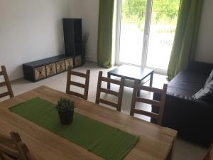 ein Wohnzimmer mit einem Tisch, Stühlen und einem Sofa in der Unterkunft Apartmány Hlohovec in Hlohovec