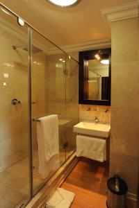 uma casa de banho com um chuveiro, um lavatório e um espelho. em Cycad Guest House em Polokwane