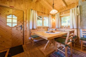 a dining room with a wooden table in a log cabin at Almliesl HOLL-559 in Hollersbach im Pinzgau