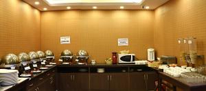 a kitchen with a counter with plates and a microwave at Hotel Sapana Garden Thamel in Kathmandu