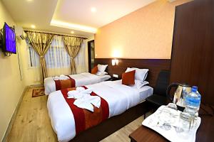 a hotel room with two beds and a television at Hotel Sapana Garden Thamel in Kathmandu
