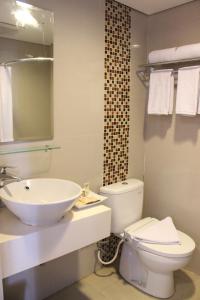 een badkamer met een wit toilet en een wastafel bij Sahid Mutiara Karawaci in Tangerang