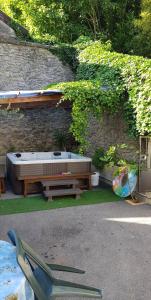 a bench and a bed in front of a stone wall at VILLA.H GARDEN in Cramant