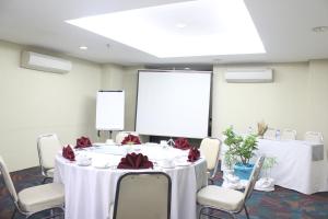 een vergaderzaal met een tafel en stoelen en een scherm bij Sahid Mutiara Karawaci in Tangerang