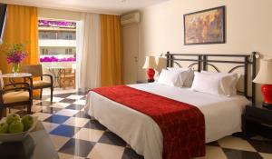 a hotel room with a bed and a dining room at Out Of The Blue Resort & Spa in Agia Pelagia